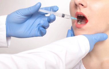 Doktor dilin biyopsisini hastanın dilinde bir şırıngayla yapıyor. Kavram kontrolü iyi huylu ve kötü huylu tümörler, dil kanseri, hastalık