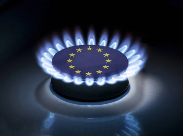 Burning gas burner of a home stove in the middle of which is the flag of the country of European Union. Gas import and export delivery concept, price per cubic meter, transit, background