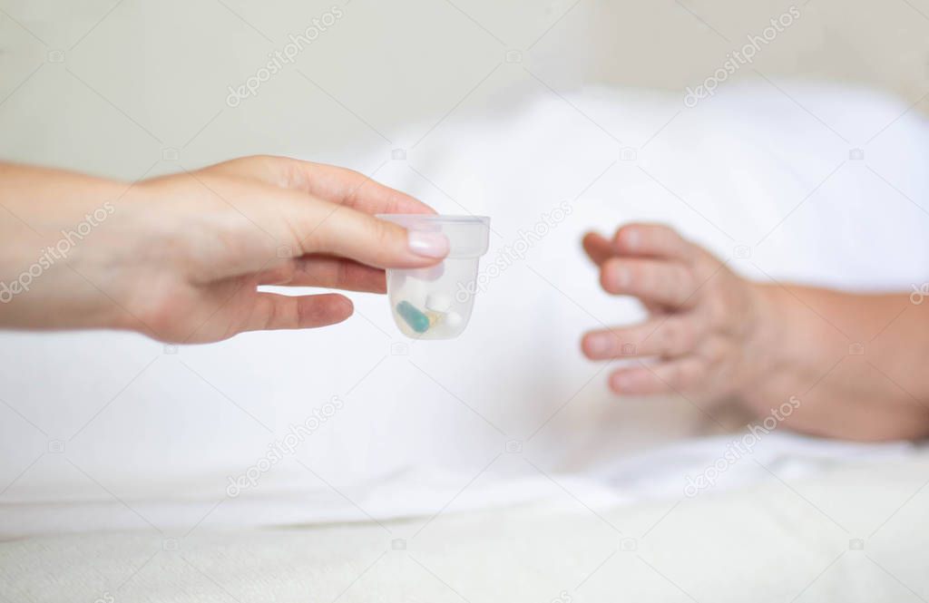 Doctor holds out anti-hypertension pills and antidepressants to an elderly woman, Pill classification concept, hepatoprotectors