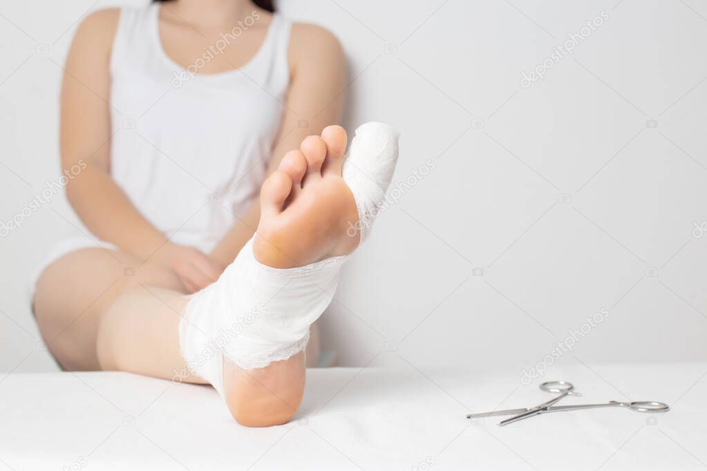Girl patient in a hospital with a broken big toe. Toe injury concept, sprain and bruise, copy space