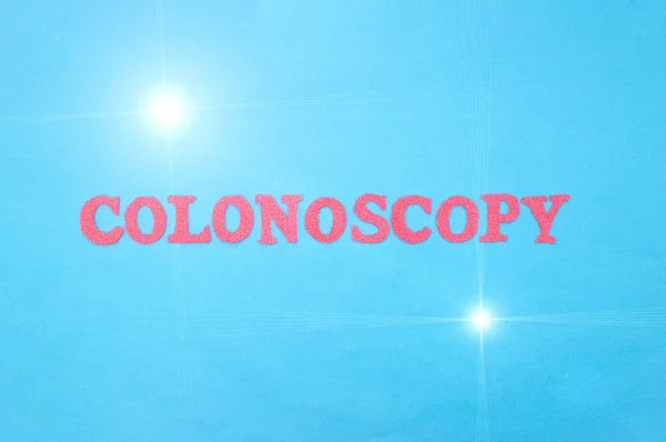 La palabra colonoscopia en letras rojas sobre un fondo azul. El concepto de un procedimiento de diagnóstico médico para examinar el colon y el recto en humanos, cáncer intestinal, gastroscopia —  Fotos de Stock