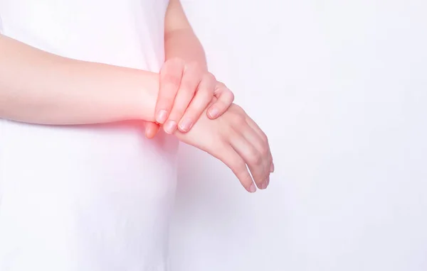 Beyaz arka planda eli ve bileği ağrıyan bir kız. Karpal kanal hastalıkları kavramı ve burkulma, kopyalama alanı, romatoloji — Stok fotoğraf