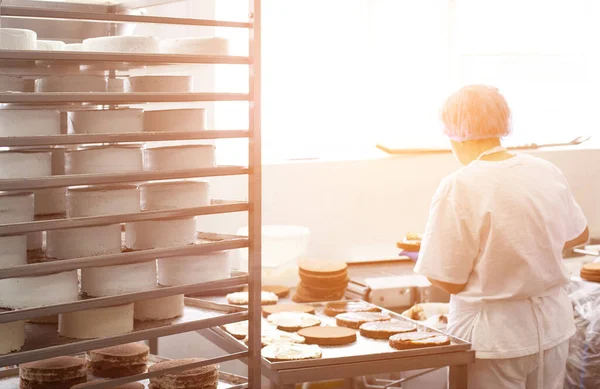 Ζαχαροπλάστης κάνει κέικ και πίτες στη βιομηχανία ζαχαροπλαστικής, το φως του ήλιου, κέικ κενό — Φωτογραφία Αρχείου
