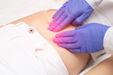 Jinekolog bir doktor, üreme sisteminde ağrı ve iltihap olan bir kızın karnının alt kısmını inceliyor. Yumurtalık kisti