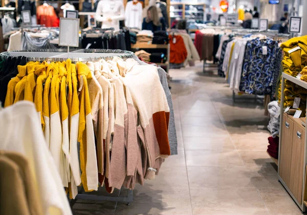 Venda e compra de itens quentes na loja para a temporada de outono e inverno. Jaquetas elegantes e elegantes e suéteres são vendidos na loja, na moda — Fotografia de Stock