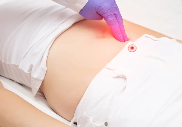Un médico traumatólogo examina la parte inferior del abdomen de una niña que tiene una lesión abdominal contundente . — Foto de Stock