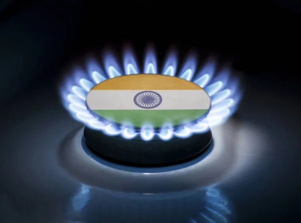 Burning gas burner of a home stove in the middle of which is the flag of the country of India. Gas import and export delivery concept, price per cubic meter, transit, background