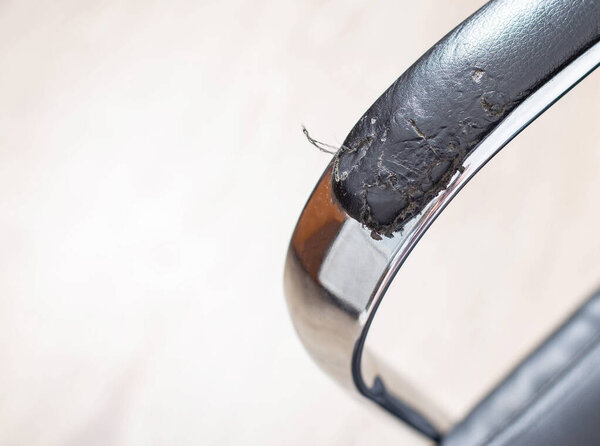 Torn and battered leather on a black office computer chair. Restoration and restoration of the leather