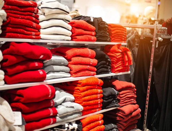 Продажа в магазине теплых вещей свитера и пиджак. Модная и стильная одежда, стопка разноцветных натуральных курток — стоковое фото