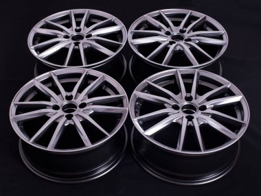 Siyah arka planda alüminyumdan yapılmış modern otomotiv alaşımı tekerleği, endüstri. Araba için tasarımcı moda tekerlekleri