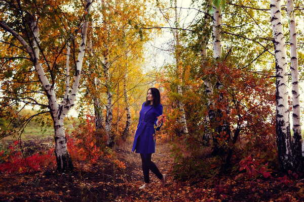 Beautiful girl walking in the autumn forest October