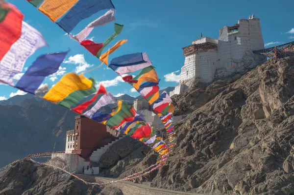 Buddhist prayer flags fluttering in the wind against the background of the Gompa in Leh, Ladakh, India