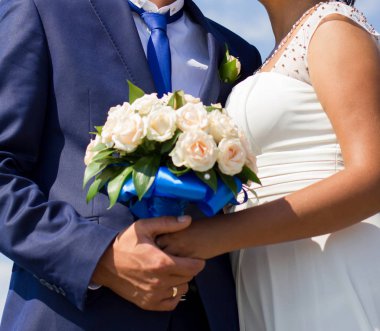 Gelin ve damat düğün buketi taşıyor.