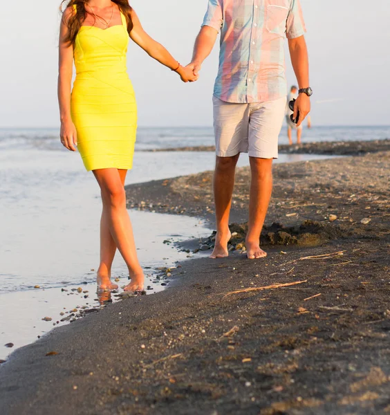 情侣们手牵手在海滩上散步 — 图库照片