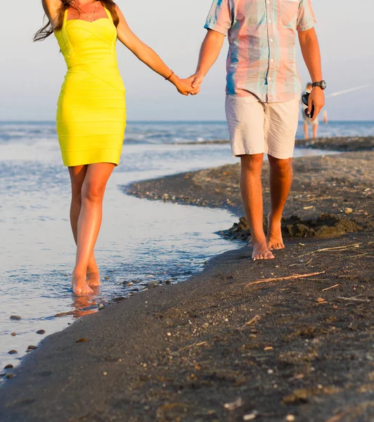 情侣们手牵手在海滩上散步 — 图库照片