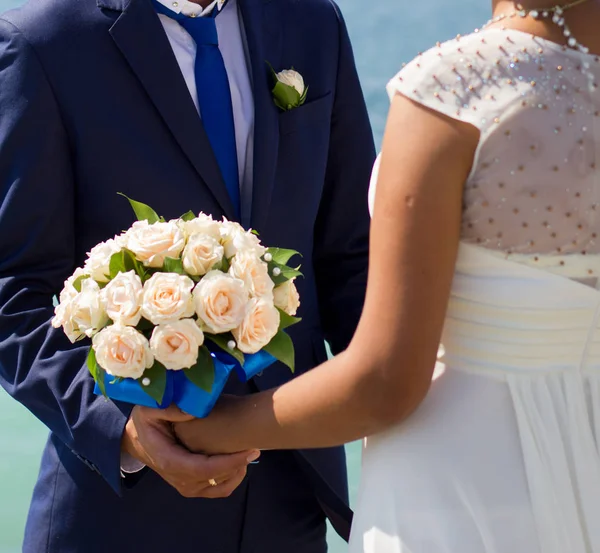 Sposa e sposo tenendo bouquet da sposa — Foto Stock