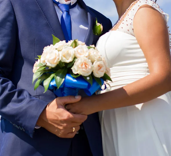 Noiva e noivo segurando buquê de casamento — Fotografia de Stock