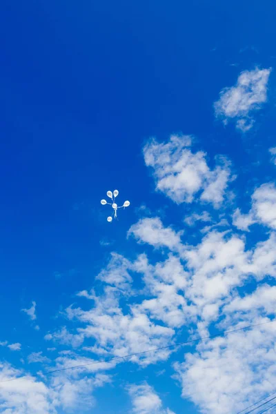 White balloons in the sky.