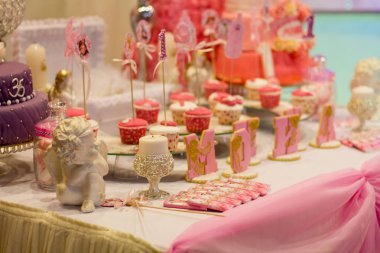 Mutlu bir bersday partide pembe bir masada tatlı büfe.