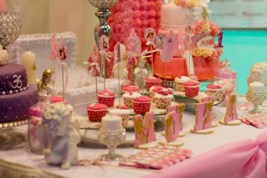 Mutlu bir bersday partide pembe bir masada tatlı büfe.