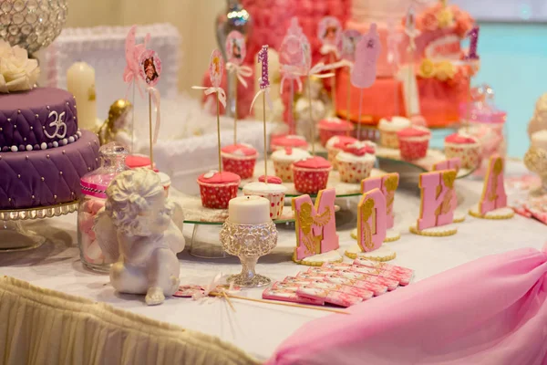 Sladký bufet na růžovém stole v šťastné celodenní párty. — Stock fotografie