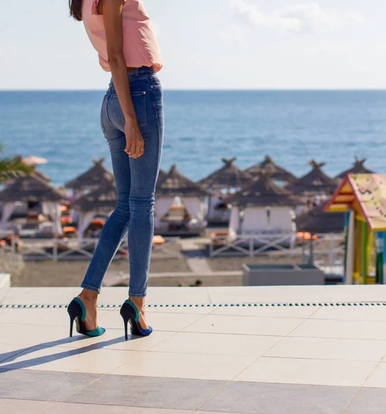 黒い海のビーチの近くにジーンズをはいている女の子 — ストック写真