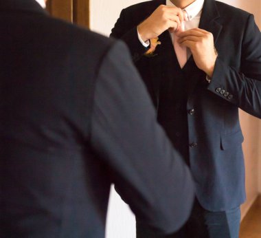 Aynanın önündeki damat elbiseleri