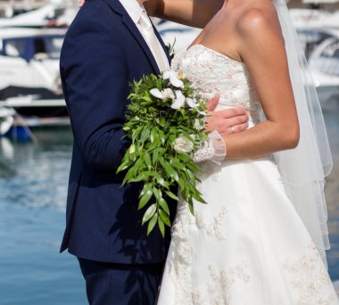 Gelin ve damat düğün buketi taşıyor.