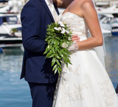 Gelin ve damat düğün buketi taşıyor.