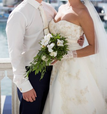 Gelin ve damat düğün buketi taşıyor.