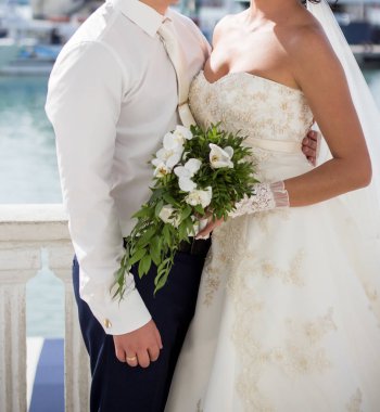 Gelin ve damat düğün buketi taşıyor.