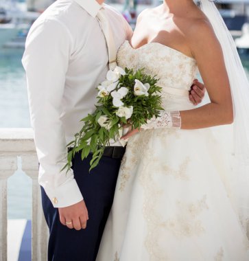 Gelin ve damat düğün buketi taşıyor.