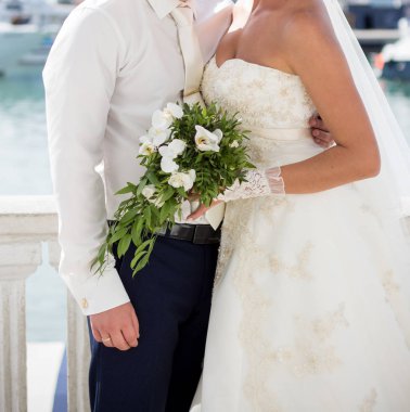 Gelin ve damat düğün buketi taşıyor.