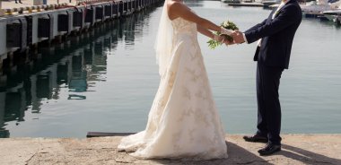 Gelin ve damat düğün buketi taşıyor.