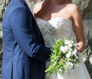 Gelin ve damat düğün buketi taşıyor.