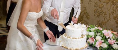 Gelin ve damat bir düğünde pasta kesiyorlar.