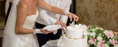 Gelin ve damat bir düğünde pasta kesiyorlar.