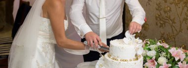 Gelin ve damat bir düğünde pasta kesiyorlar.