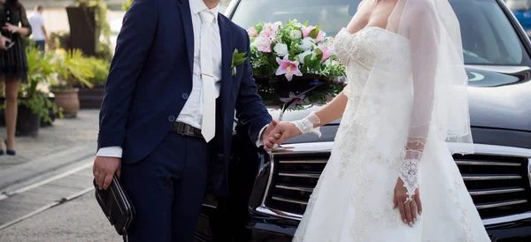 Gelin ve damat önünde duran düğün araba