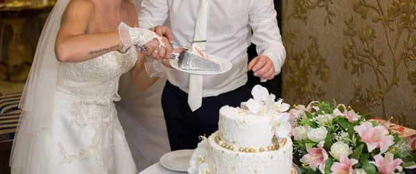 花嫁と新郎の結婚式でケーキを切る — ストック写真