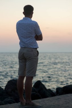 Deniz kıyısı üzerinde duran bir adam