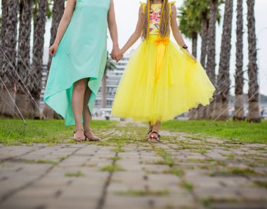 Anne ve kızı avuç içi arasında parkta yürüyüş