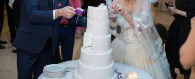 Gelin ve damat bir düğünde pasta kesiyorlar.