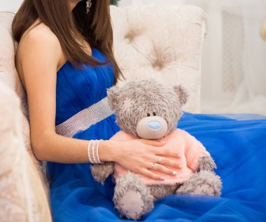 Büyük bir oyuncak ayının içinde oturan kadın.