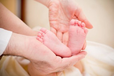 Bebek ayaklar ebeveynlerin elinde. Hafif arkaplan