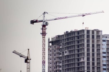 İnşaat vinci inşaat halindeki yeni bir evin yanında.