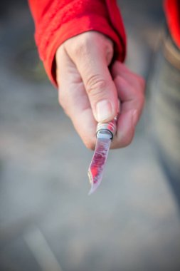 Bir katilin elinde tehlikeli bir bıçak var. Bıçakta kırmızı renk var.