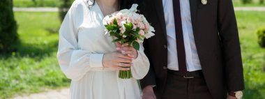 Karantina döneminde bir çıkış töreninde buketi olan yeni evliler.