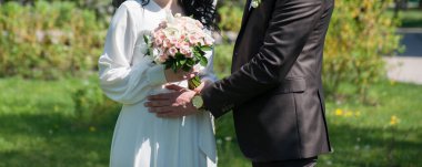 Karantina döneminde bir çıkış töreninde buketi olan yeni evliler.