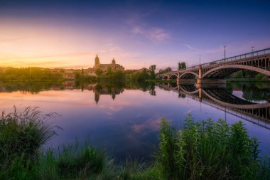 Salamanca görünümünü nehre günbatımı sırasında yansıyan.